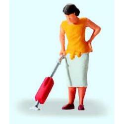 Mujer limpiando con aspiradora.